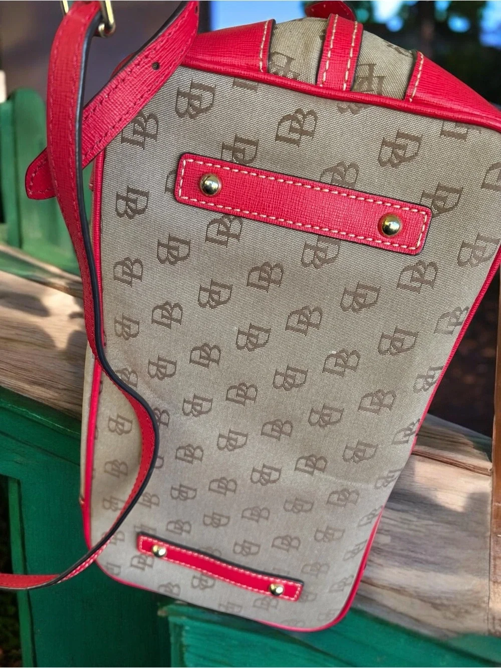 Dooney & Bourke Signature monogram satchel features vibrant pink leather trim
